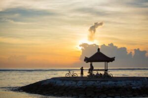 cyclist enjoy sunrise at sanur beach bali